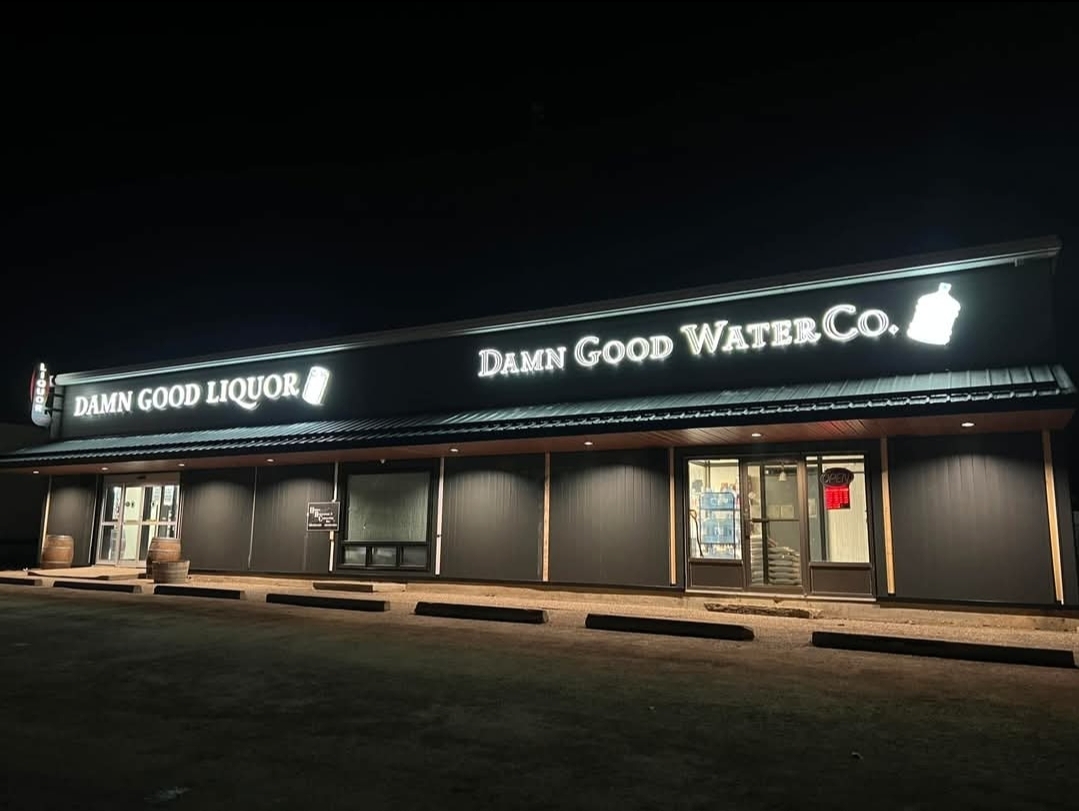Damn Good Liquor and Damn Good Water Co. storefront at night